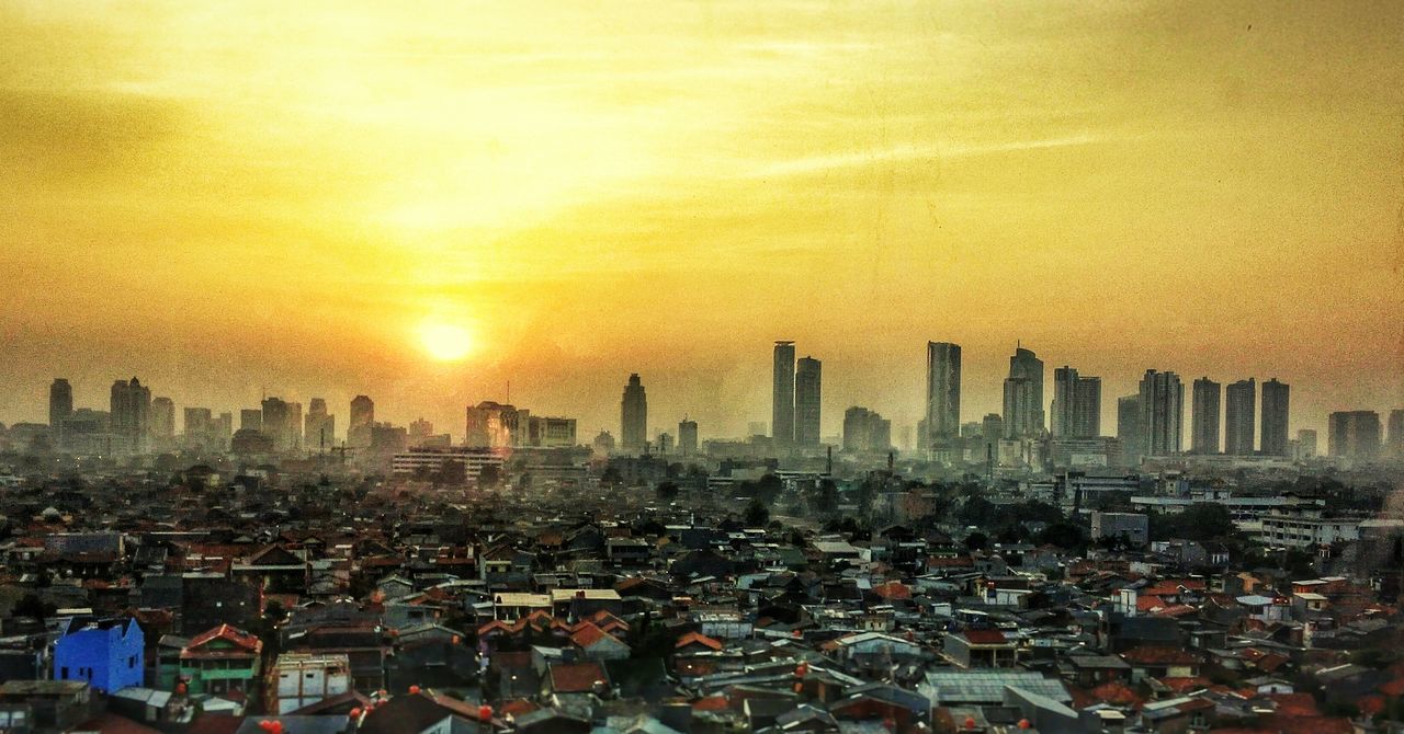 sunset, cityscape, city, building exterior, architecture, built structure, skyscraper, tower, tall - high, orange color, urban skyline, sky, crowded, sun, modern, office building, city life, high angle view, sunlight, capital cities