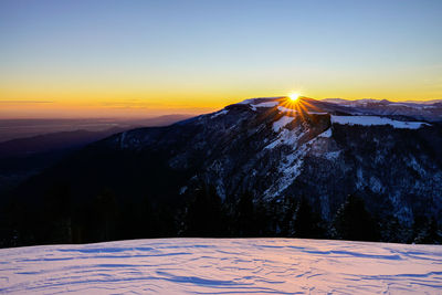Scenic view of snowcapped mountains against sky during sunset