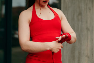 Midsection of woman holding red while standing outdoors