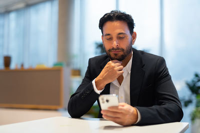 Portrait of businessman using mobile phone in office