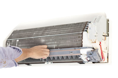 Cropped hand of man repairing air conditioner