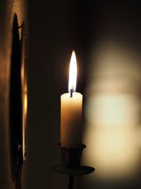 Close-up of illuminated candle in darkroom