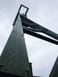 Low angle view of crane against sky