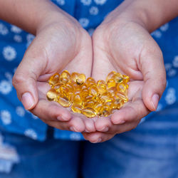 Close-up of woman hands holding cod pills