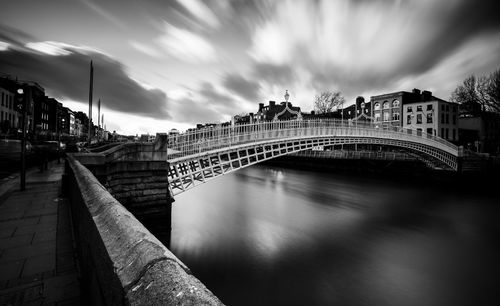 Arch bridge over river against buildings in city