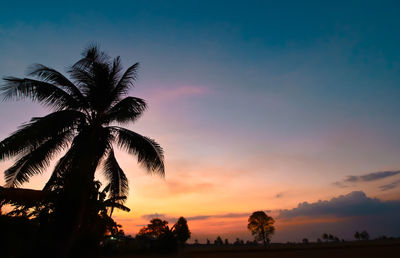 Low angle view of silhouette palm trees against romantic sky