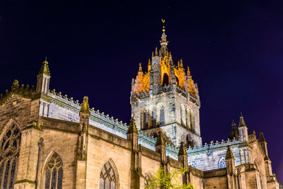 Low angle view of illuminated building against sky at night