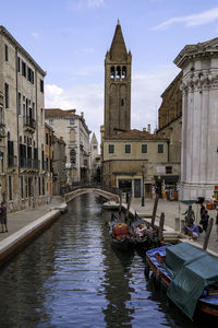 Colorful traditional venetian houses in a canal with a church tower - quiet morning in venice