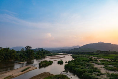 Scenic view of river against sky during sunset