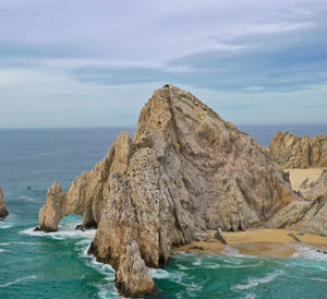 Scenic view of rock formation in sea against sky