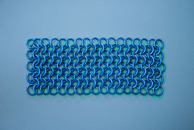 Close-up of chain mail on blue background