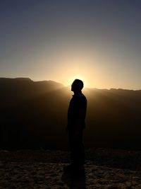 Rear view of man standing against sky during sunset