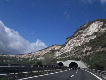 Road by mountain against sky