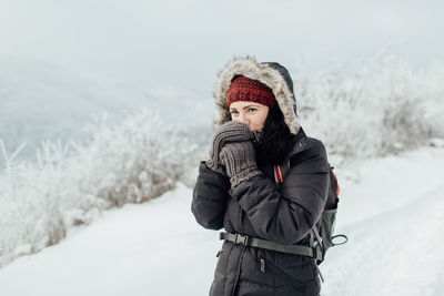 Woman standing on snow covered landscape during winter