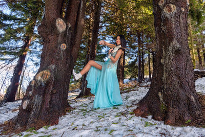 Woman playing on violin in the forest