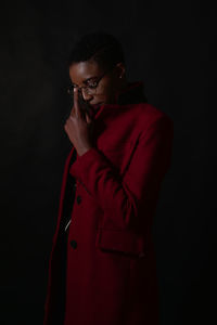 Young man wearing mask against black background