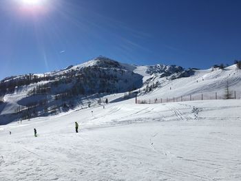 Scenic view of snowcapped mountains on sunny day