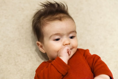 Close-up of cute boy lying down on floor