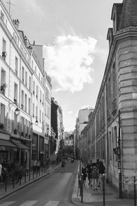 People walking on road along buildings