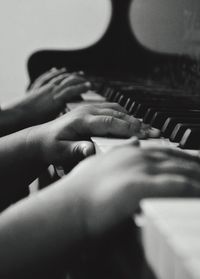 Close-up of hands playing piano