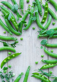 Green peas with leaves on a wooden background