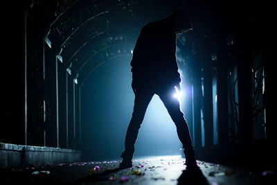 Low section of woman standing in tunnel