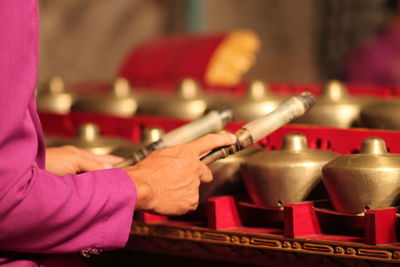 Cropped image of man playing gamelan