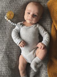 Portrait of cute boy lying down on sofa at home