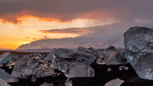 Dramatic sunset over melting ice on the beach