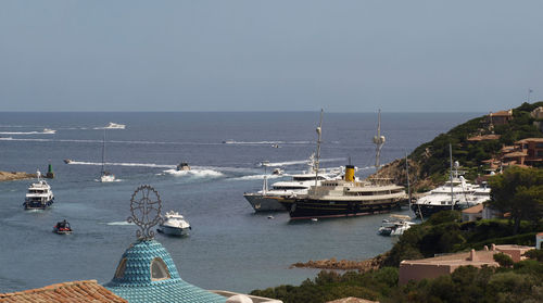 Sailboats sailing in sea against clear sky