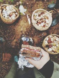 Cropped image of hand holding sandwich at outdoors
