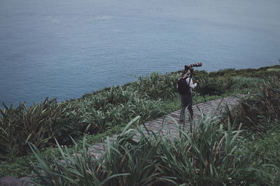 Man photographing at sea shore