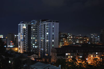 High angle view of illuminated buildings against sky at night