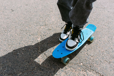 Young stylish woman wears sunglasses walks on the street with a skateboard