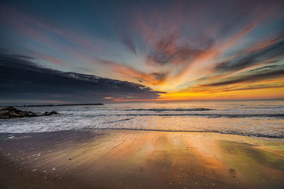 Scenic view of beach against sky during sunset