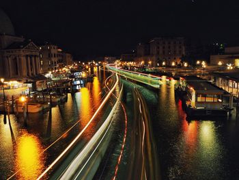 High angle view of illuminated street amidst buildings at night