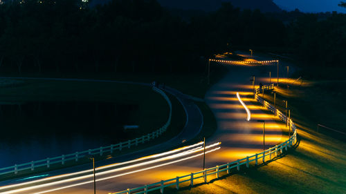 High angle view of light trails on road by lake