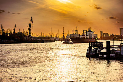 Boats in sea against sky during sunset