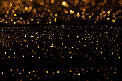 Defocused image of illuminated city against sky at night