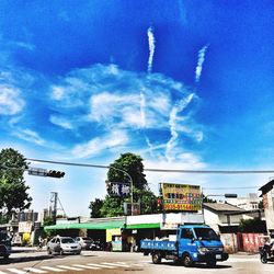 Cars on road against cloudy sky