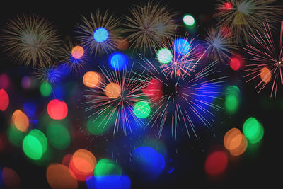 Low angle view of illuminated firework display at night