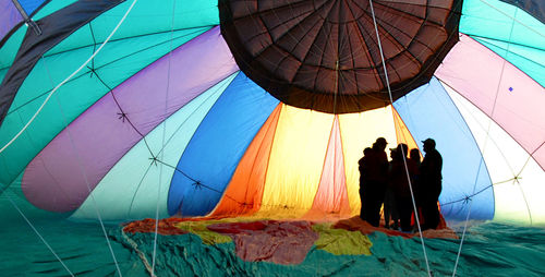 People in multi colored umbrellas against blue sky