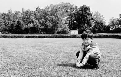 Portrait of boy sitting on tree