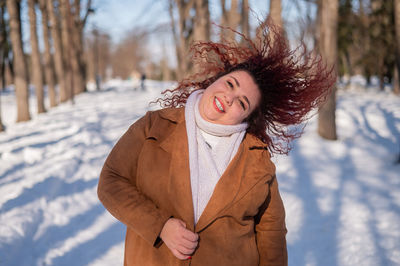 Portrait of woman standing on snow covered field