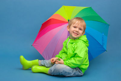 Cute boy smiling against blue background