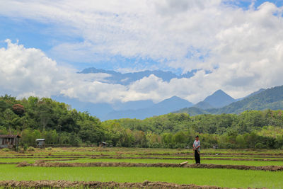 Man standing on field against sky