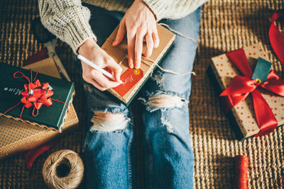 Woman wrapping christmas gifts for mother at home. 