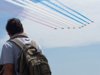 Rear view of man flying against sky