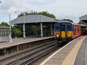 Train at railroad station against sky