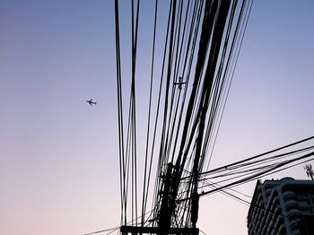 Low angle view of birds flying against clear sky